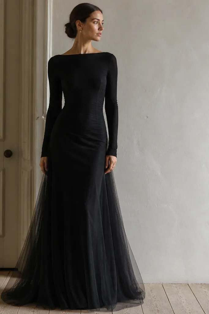 A black long sleeve evening dress with a stretch slip underneath and a black tulle overlay on the skirt, fitted upper body, long sleeves, ankle-length hem.
